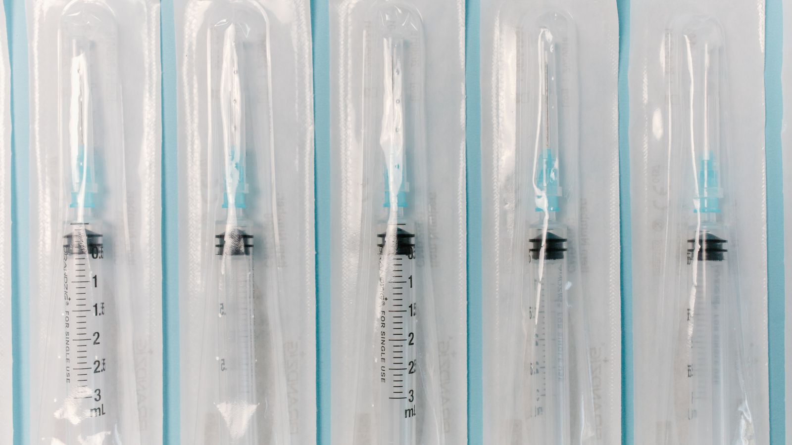 Close-up of sterile syringes still sealed in their individual packaging.